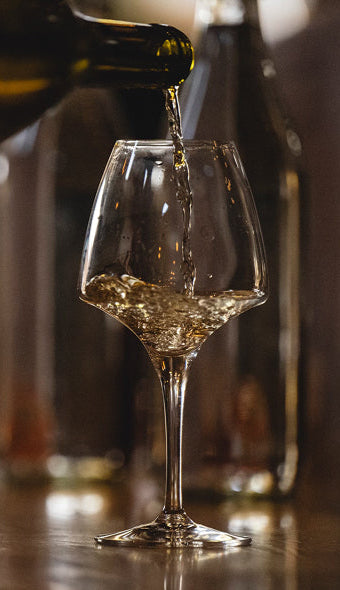 wine being poured into a glass with a blurred background