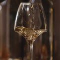 wine being poured into a glass with a blurred background