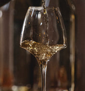 wine being poured into a glass with a blurred background